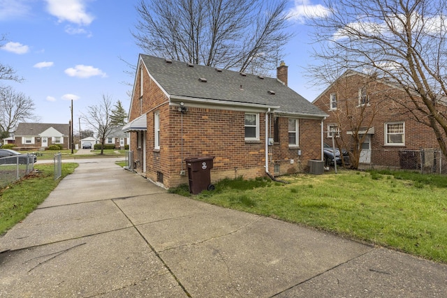 8450 Warren Blvd, Center Line, MI 48015 - rear view of property featuring a chimney, driveway, fence, a yard, and brick siding