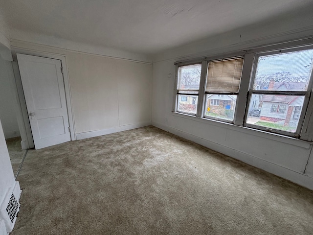 carpeted empty room with visible vents and baseboards