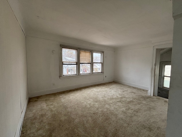 spare room featuring baseboards and carpet flooring