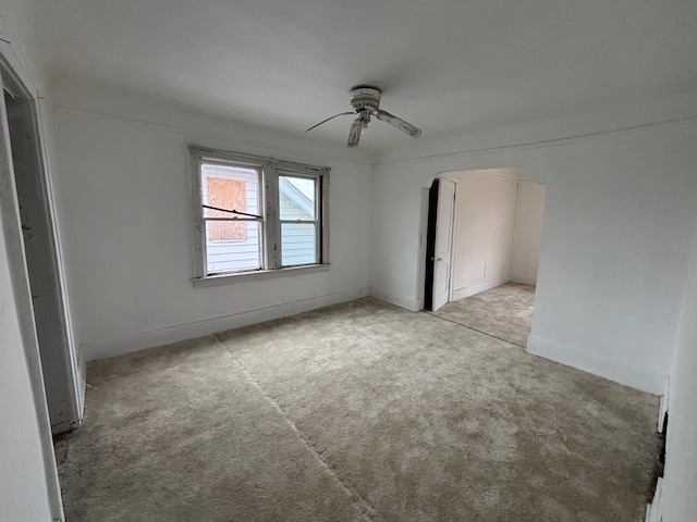 unfurnished bedroom with ceiling fan, baseboards, and light carpet