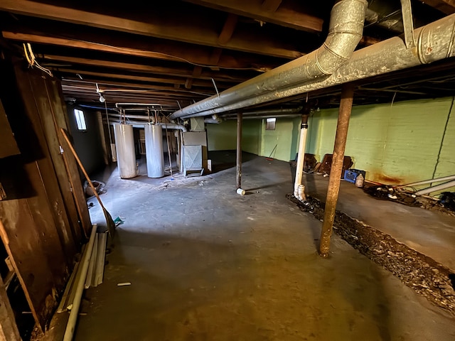 unfinished basement with water heater and heating unit