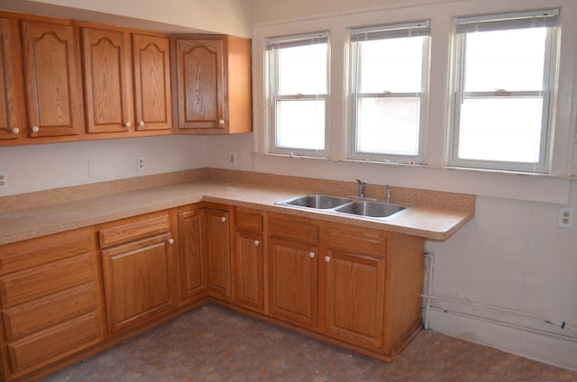 kitchen featuring a sink, light countertops, and brown cabinetry