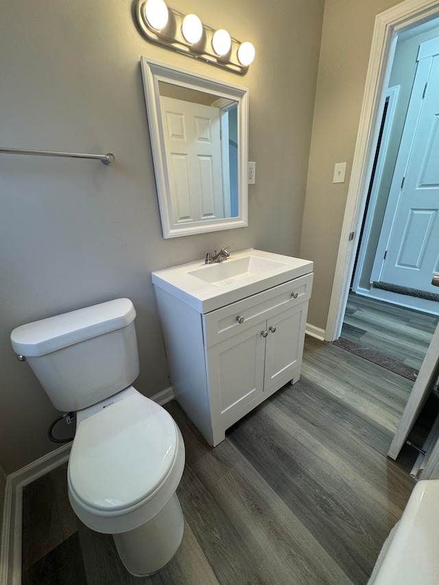 22051 Firwood Ave, Eastpointe, MI 48021 - bathroom featuring baseboards, wood finished floors, vanity, and toilet