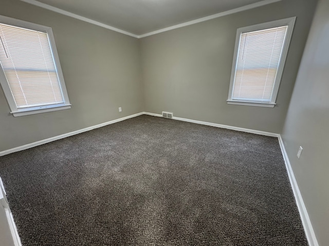 22051 Firwood Ave, Eastpointe, MI 48021 - unfurnished room with crown molding, a healthy amount of sunlight, dark carpet, baseboards, and visible vents