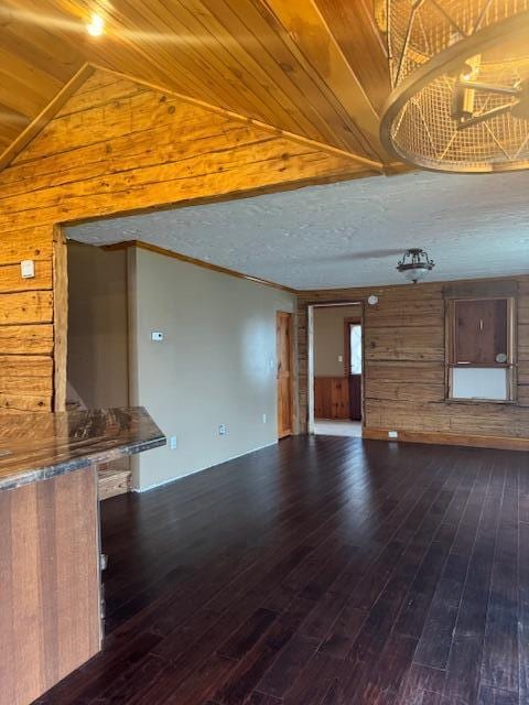 314 W Main, Whitehall, MI 49461 - unfurnished living room with wood walls, lofted ceiling, and dark wood-type flooring