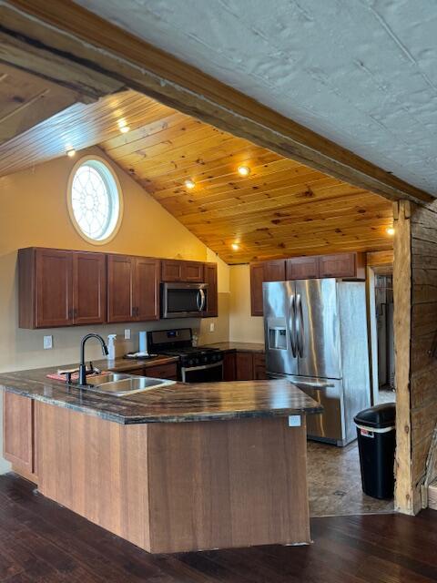 314 W Main, Whitehall, MI 49461 - kitchen with a sink, a peninsula, appliances with stainless steel finishes, dark wood-style flooring, and vaulted ceiling with beams