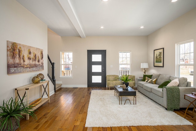 living room with stairway, healthy amount of natural light, hardwood / wood-style floors, recessed lighting, and beam ceiling