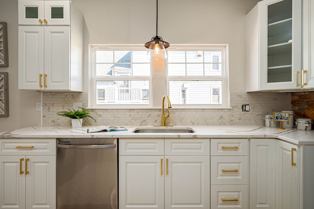 kitchen featuring stainless steel dishwasher, a sink, white cabinetry, and backsplash