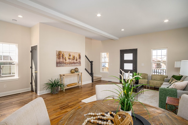 living room with stairs, healthy amount of natural light, wood finished floors, and recessed lighting
