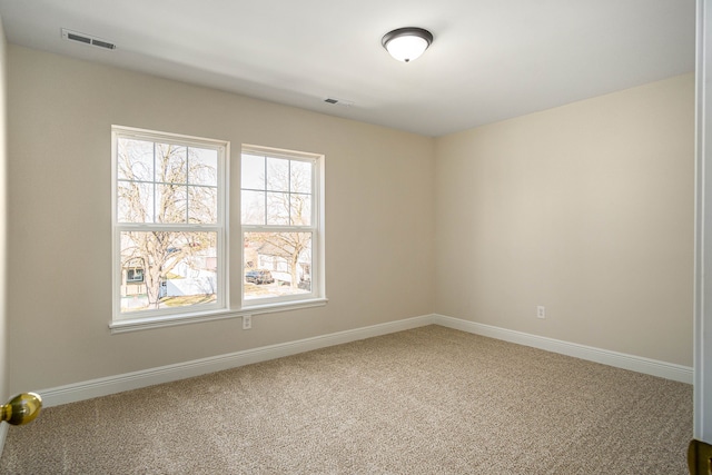 carpeted spare room featuring plenty of natural light and baseboards