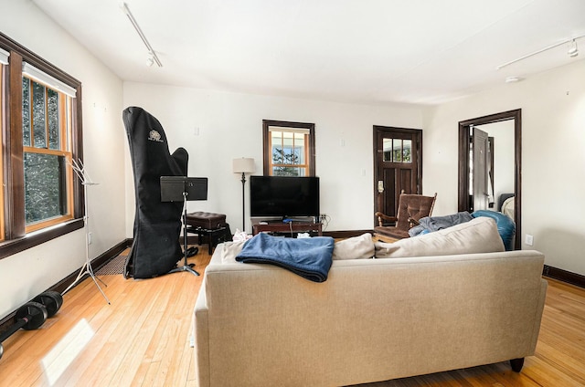 living room with rail lighting, baseboards, and wood-type flooring