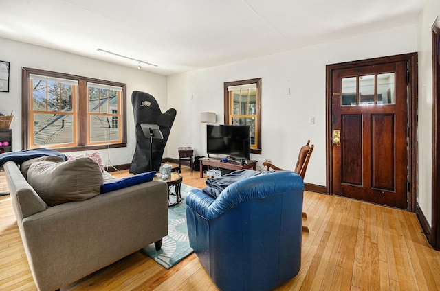 living area featuring light wood finished floors and baseboards