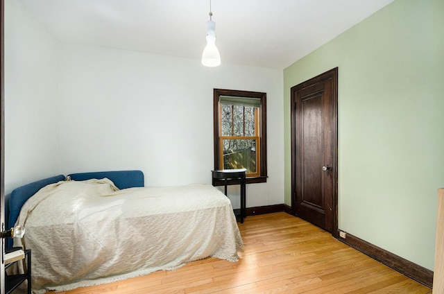 bedroom with light wood finished floors and baseboards