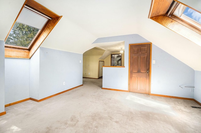 bonus room with baseboards, visible vents, carpet flooring, and vaulted ceiling with skylight