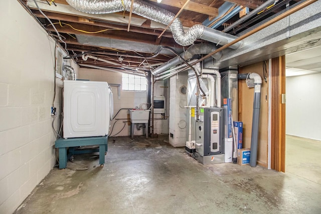 basement featuring washer / dryer, heating unit, and a sink