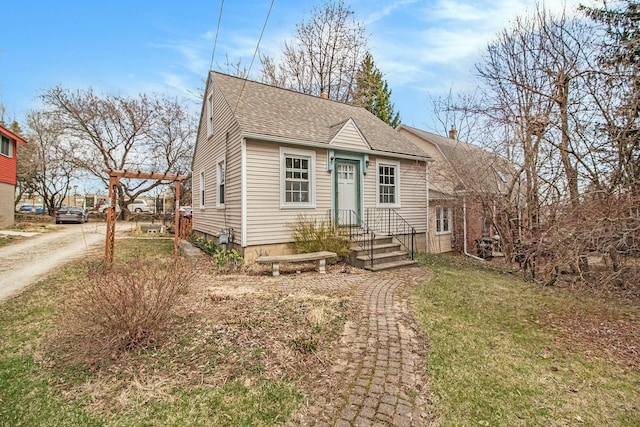 view of front facade featuring a front lawn and roof with shingles