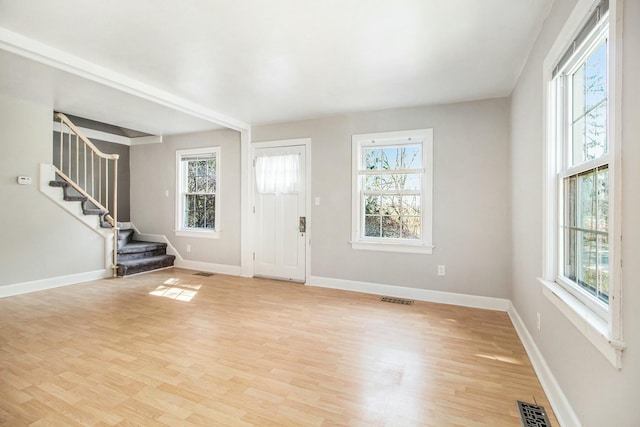 foyer with stairway, a healthy amount of sunlight, and visible vents
