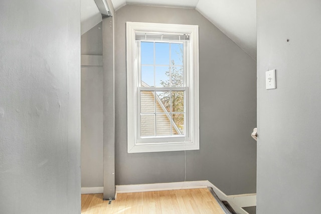 bonus room with vaulted ceiling, wood finished floors, and baseboards