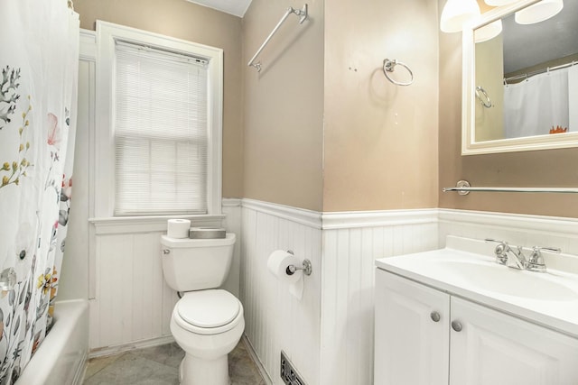 bathroom with wainscoting, toilet, vanity, and tile patterned floors