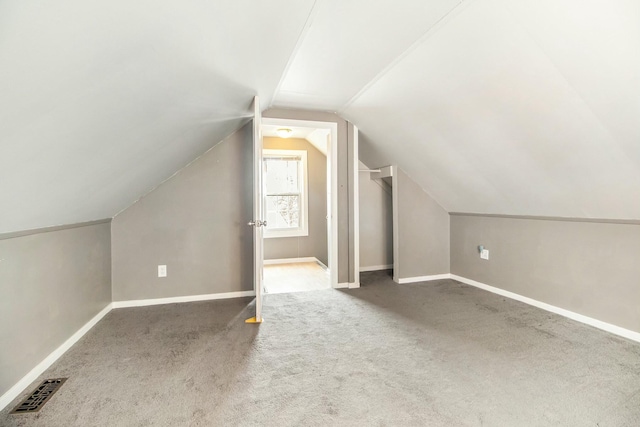 bonus room with baseboards, vaulted ceiling, visible vents, and carpet