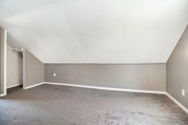 bonus room featuring vaulted ceiling, carpet, and baseboards