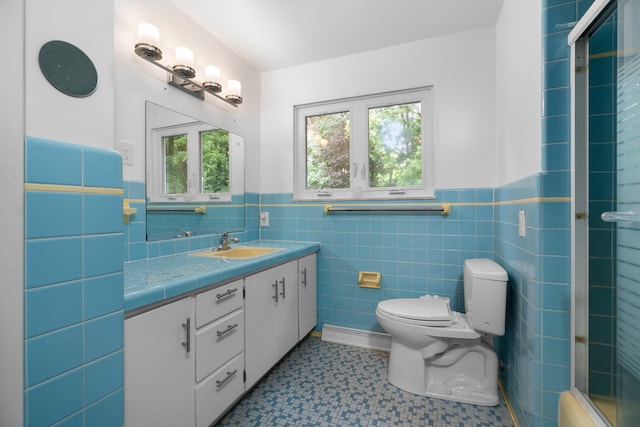 3091 Warwick Rd, Ann Arbor, MI 48104 - full bathroom featuring a wainscoted wall, an enclosed shower, toilet, vanity, and tile walls