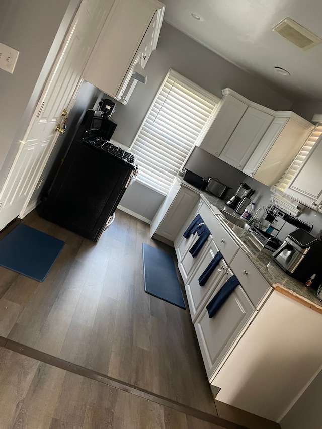 15425 Sorrento St, Detroit, MI 48227 - kitchen with white cabinetry, wood finished floors, and visible vents