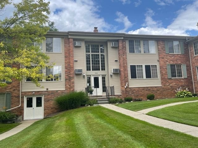 500 Romeo Rd Unit 116, Rochester, MI 48307 - view of front facade with a chimney, brick siding, and a front yard