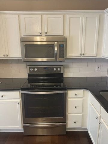 500 Romeo Rd Unit 116, Rochester, MI 48307 - kitchen with white cabinets, dark countertops, decorative backsplash, and stainless steel appliances