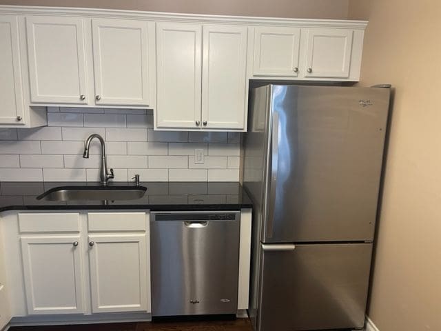 500 Romeo Rd Unit 116, Rochester, MI 48307 - kitchen with a sink, dark countertops, stainless steel appliances, white cabinetry, and tasteful backsplash