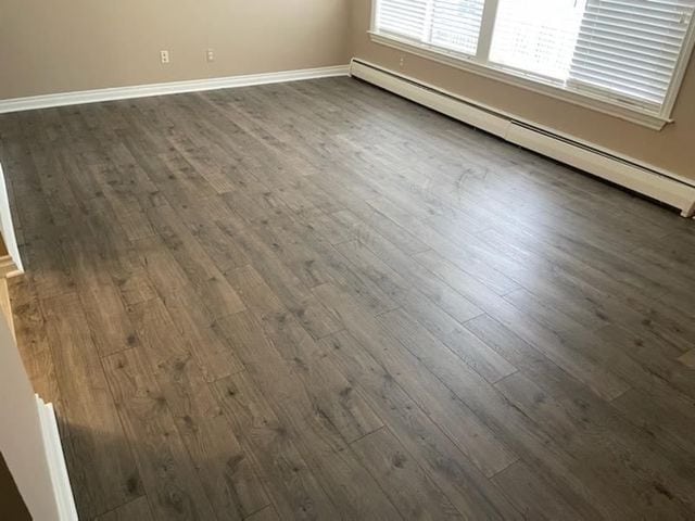 500 Romeo Rd Unit 116, Rochester, MI 48307 - spare room with dark wood finished floors, baseboards, and baseboard heating