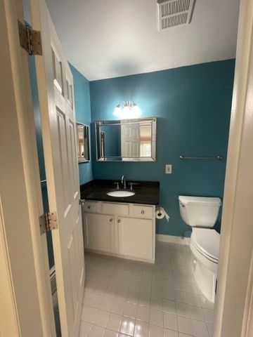 500 Romeo Rd Unit 116, Rochester, MI 48307 - half bathroom with toilet, vanity, visible vents, tile patterned flooring, and baseboards