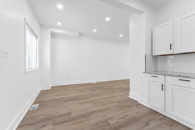 interior space with baseboards, light wood-style flooring, visible vents, and recessed lighting