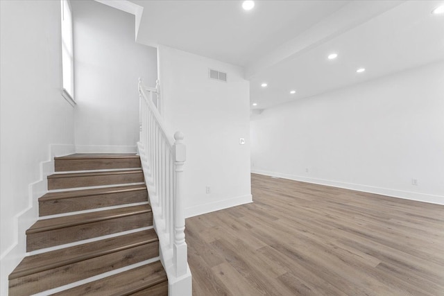 stairway with recessed lighting, wood finished floors, visible vents, and baseboards