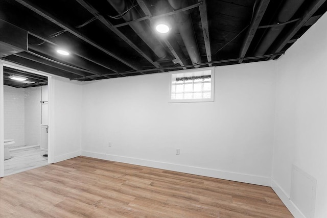 basement with visible vents, baseboards, and wood finished floors