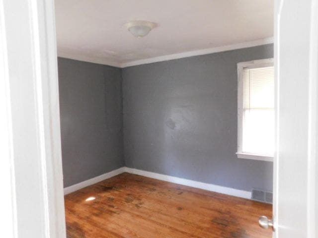 15864 Bringard Dr, Detroit, MI 48205 - spare room featuring wood finished floors, visible vents, and crown molding
