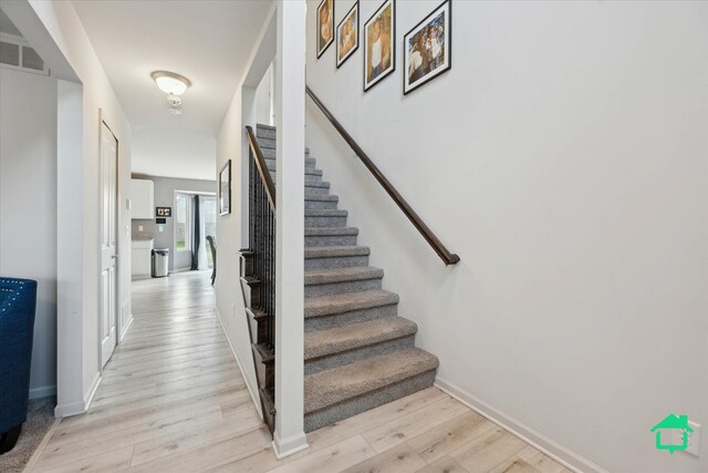 staircase featuring baseboards, wood finished floors, and visible vents