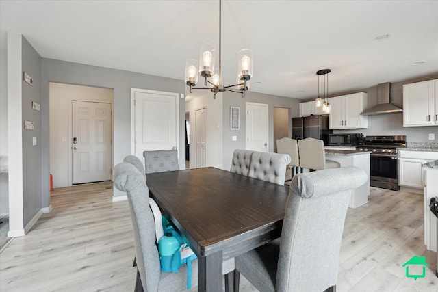 dining space featuring light wood-style flooring, baseboards, and a chandelier