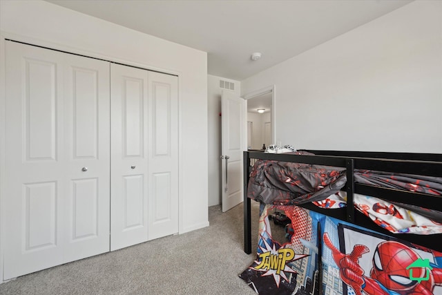 bedroom with visible vents, carpet floors, and a closet