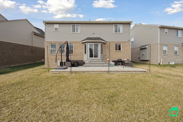 rear view of house featuring a yard, brick siding, a patio area, and entry steps