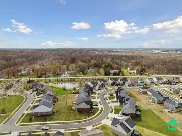 aerial view featuring a wooded view, a residential view, and a water view