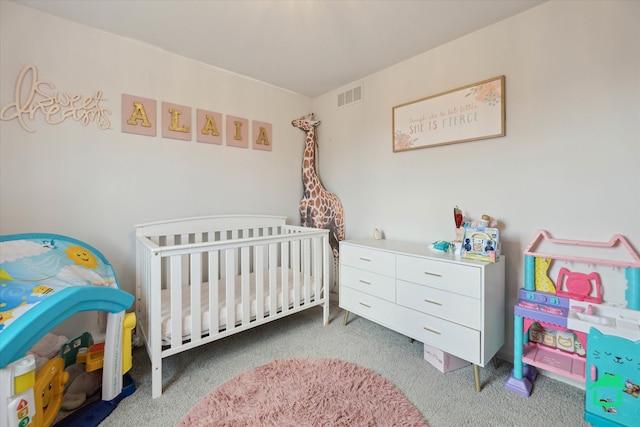 carpeted bedroom featuring visible vents and a crib