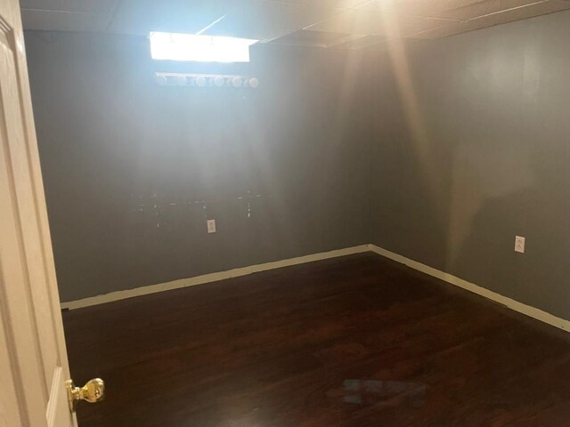 spare room with dark wood finished floors and baseboards
