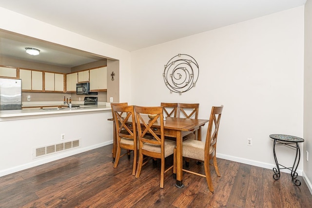 6472 Lochaven Ln, Waterford, MI 48327 - dining room featuring dark wood-type flooring and baseboards
