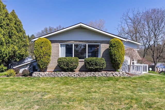 view of side of property featuring brick siding and a lawn