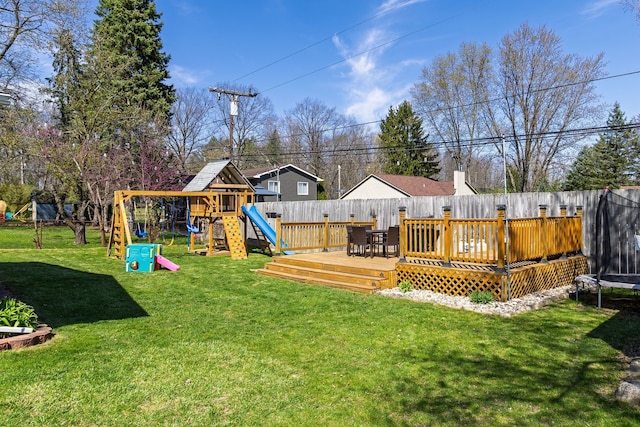 exterior space featuring a fenced backyard, a wooden deck, a playground, and a trampoline