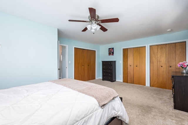bedroom featuring a ceiling fan, carpet floors, and two closets