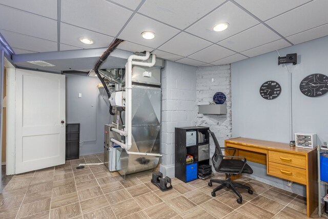 office area with a drop ceiling and heating unit