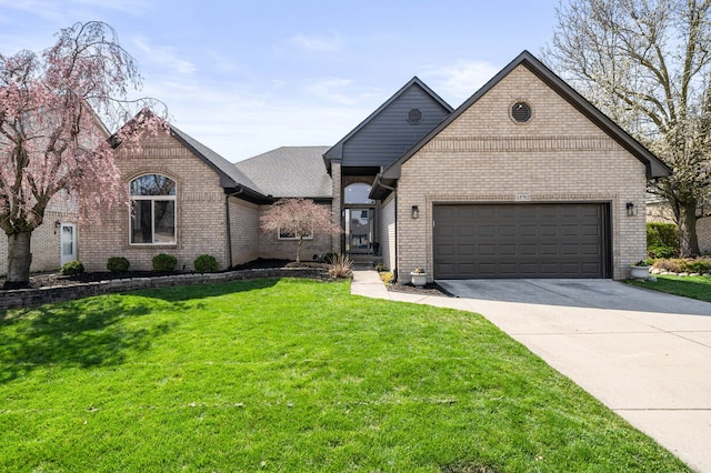 french country style house featuring concrete driveway, an attached garage, brick siding, and a front yard