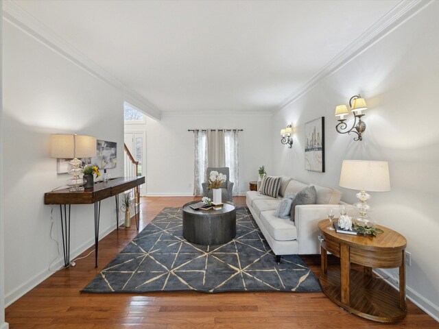 living room featuring baseboards, wood finished floors, stairs, and ornamental molding